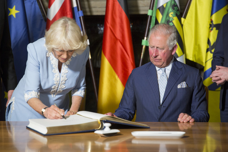 Camilla, Herzogin von Cornwall, trägt sich in das Goldene Buch ein, Prinz Charles sitzt daneben.