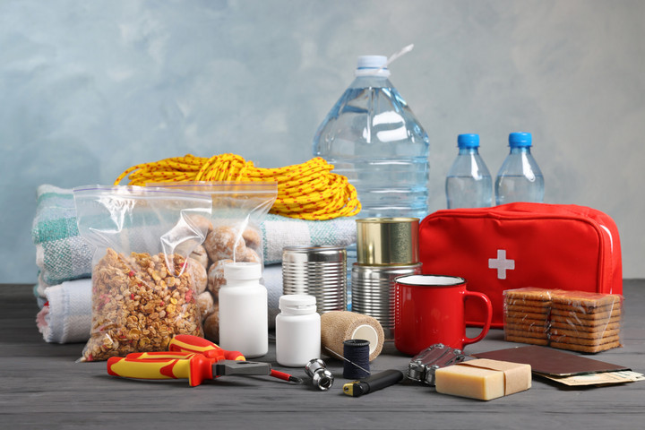 Verschiedene Dinge zum Vorsorgen für Katastrophen. Zum Beispiel: Wasserflaschen, Konservendosen, Erste Hilfe Tasche, Tabletten, Knächebrot, Bargeld