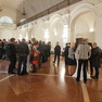 Verschiedene Personen stehen an Stehtischen in der Oberen Wandelhalle des Neuen Rathauses.