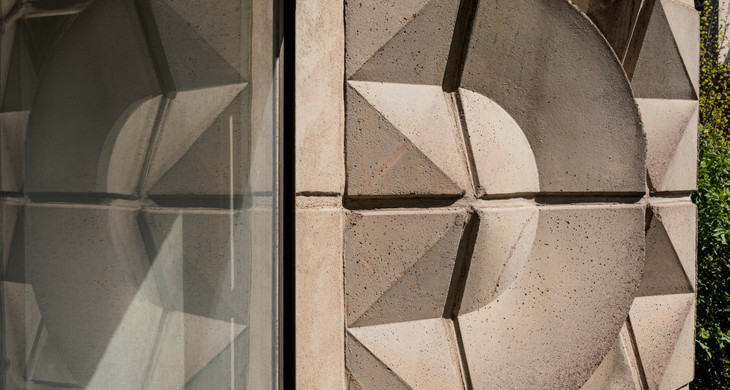 Aus Beton geformtes Gestaltungselement mit Dreiecken und Rundungen an einer Hausfassade