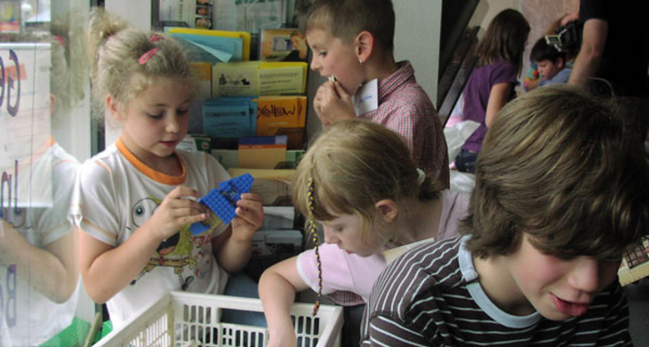 Kinder greifen in eine Kiste mit Spielzeug