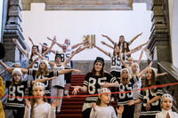 Mädchen und junge Frauen in schwarz-weiß gehaltener Sportbekleidung in Trikots mit der Nummer 85 tanzen choreografiert auf einer roten Treppe 