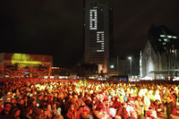 Tausende Menschen stehen auf dem Auhustusplatz, im Hintergrund leuchtet am Hochhaus eine 89