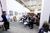 Auktion von Kunstgegenständen in einer großen Halle mit viel Publikum