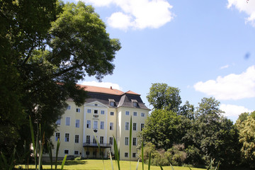 Ansicht des Schlosses in Leipzig Knauthain mit einem grünen Umfeld.