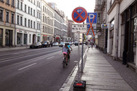 Straße mit Radfahrern und Verkehrsschildern Halteverbot und Parken durchgestrichen.