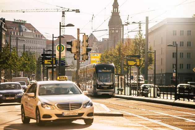 Straßenszene in Leipzig mit Autos, Straßenbahn und Radfahrern