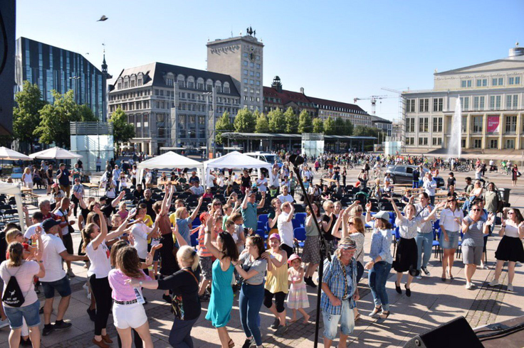 Viele Menschen tanzen beim Internationalen Begegnungsfestival auf dem Augustusplatz