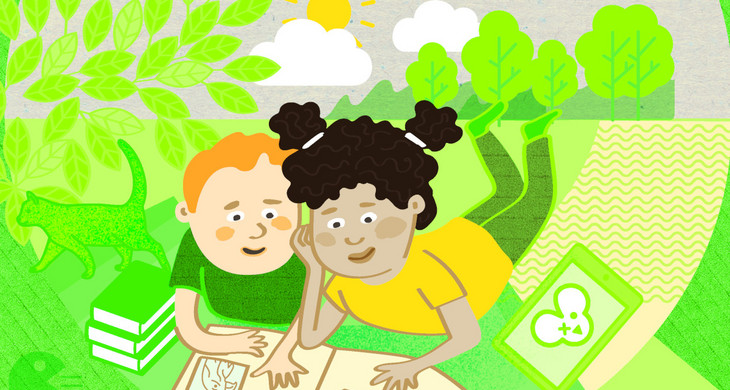 Ein Junge und ein Mädchen liegen im Grünen vor einem Buch