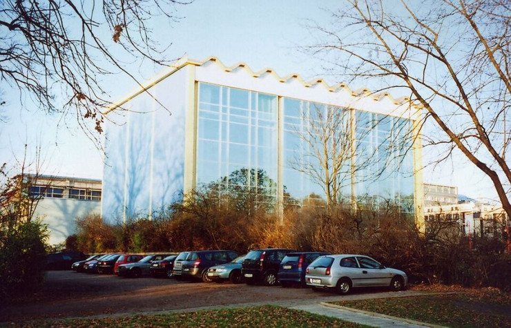 Hohes Gebäude mit großer Glasfront, in dem sich die Sprunghalle der Universität Leipzig befindet.