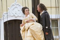 Eine Frau in barocker Kleidung blickt etwas ängstlich auf den hinter ihr stehenden Mann.