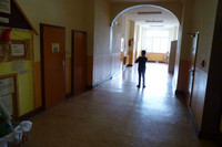 Ein Kind steht mit einem Messgerät im Flur einer Schule