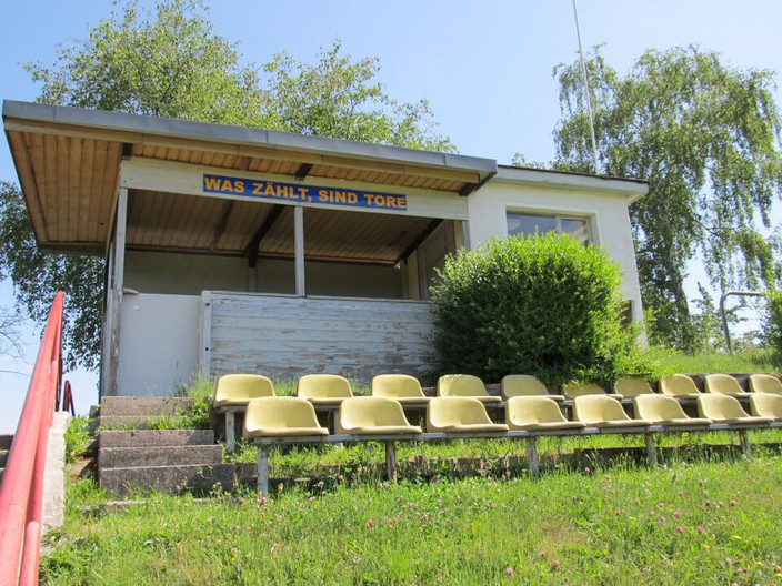 Grasbewachsene Tribüne des Erich-Steinfurth-Stadion mit zwei Sitz-Reihen.