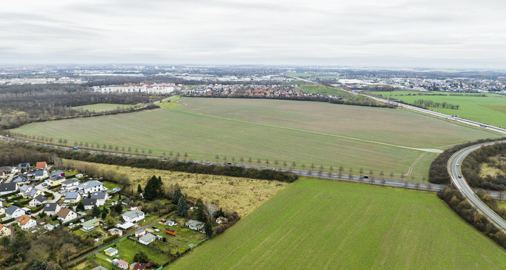 Luftbild mit Blick auf den Plaungsbereich aus Richtung Südost mit Feldern und Wiesen sowie einer aus Einfamilienhäusern bestehenden Siedlung