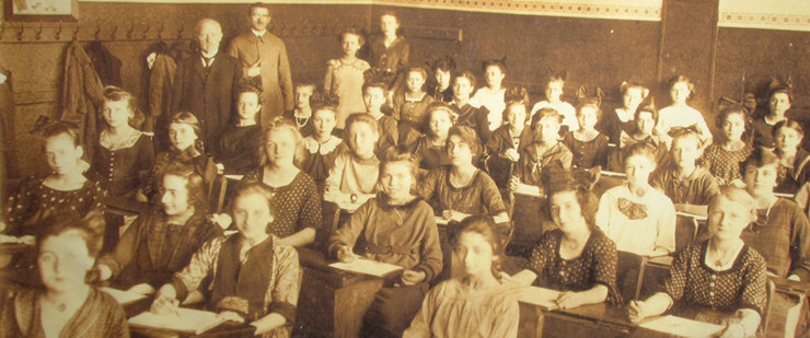 Klassenfoto einer Mädchenklasse mit Lehrern im Klassenzimmer, um 1925