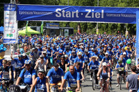 Viele Radfahrer beim Massenstart des LVZ Fahrradfestes. Fast alle tragen ein blaues T-Shirt. Über den Radfahrern in ein großes Banner mit der Aufschrift Start Ziel