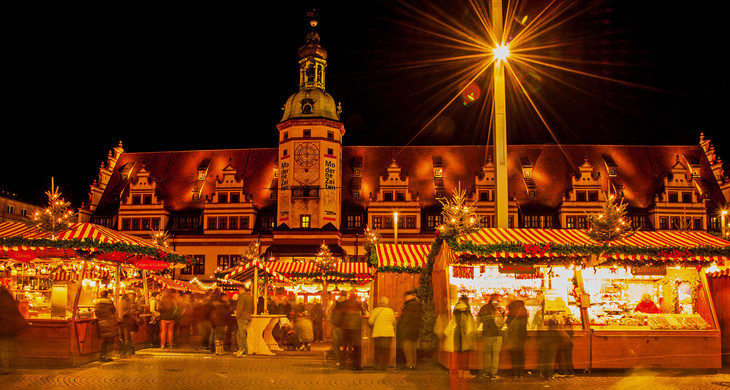 Weihnachtsmarktstände vor dem Alten Rathaus. Es ist dunkel, die Stände sind weihnachtlich beleuchtet.