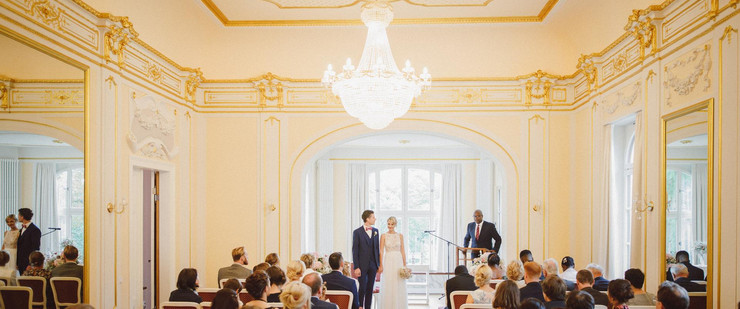 Hochzeitspaar, Standesbeamter und Gäste in einem festlichen Raum im Herrenhaus Möckern.