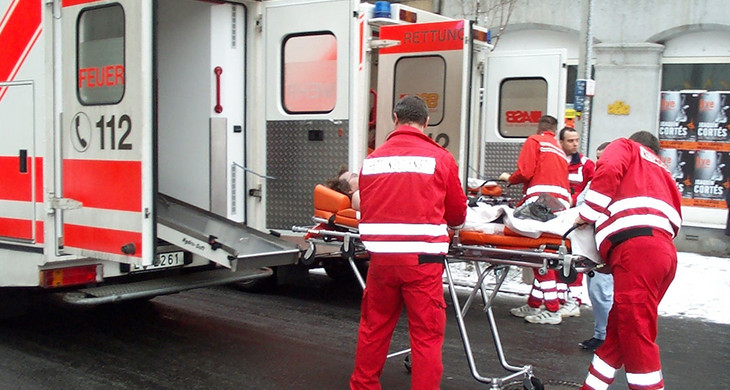 Sanitäter von Feuerwehr und Arbeiter-Samariter-Bund schieben einen Verletzten auf einer Rolltrage zum Rettungswagen.