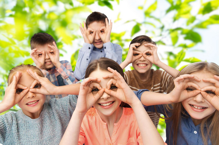 sechs Kinder formen eine Brille aus ihren Fingern und schauen durch