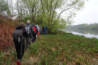 Gruppe von Menschen bei einer Wanderung am Rande eines Flusses