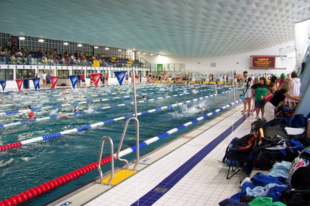 Schwimmhalle der Universität Leipzig bei einem Wettkampf mit vielen Zuschauern und Schwimmern