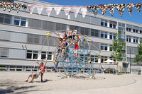 Sanierte Grundschule in der Bernhard-Göring-Straße, im Vordergrund Kinder auf einem runden Klettergerüst