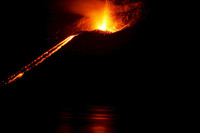 Dunkles Bild mit einem feurigen Eruption eines Vulkans