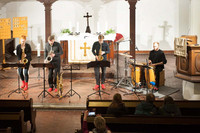 Im Altarraum der Auferstehungskirche spielen vier Musiker, alle mit roten Schuhen.