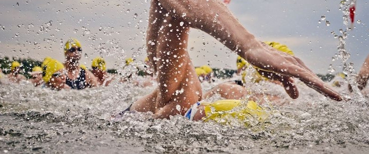 Nahaufnahme kraulender Schwimmer mit gelber Badekappe