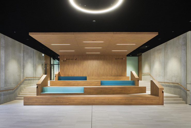Innenraum mit Blick auf Flur mit Sitzgelegenheiten aus Holz mit blauen Akzentuierungen.