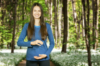Eine junge Frau in blauem Shirt im Frühlingswald