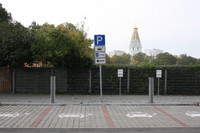 Vier markierte Parkflächen für Elektroautos auf einem Steinpflaster. Dahinter ein Verkehrszeichen mit einem Parkschild und einem Auto mit Stecker.