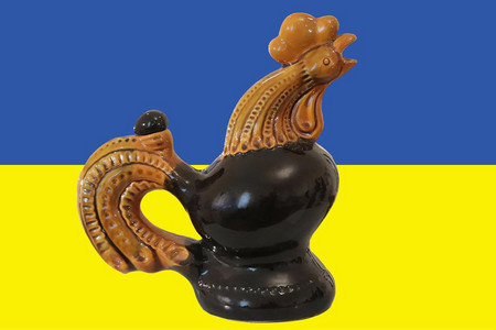 Ein Hahn aus Keramik vor einer ukrainischen Flagge