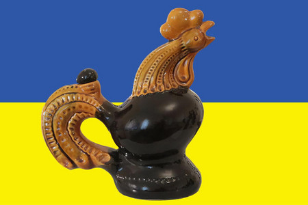 Ein Hahn aus Keramik vor einer ukrainischen Flagge