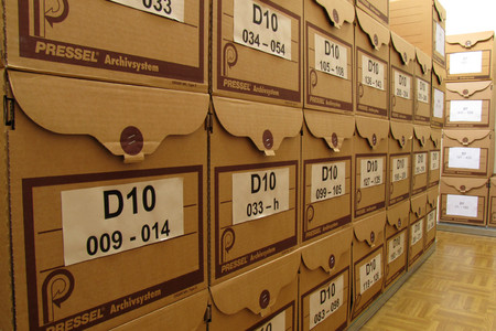 Ein Blick in das Archiv, bzw. Dokumentendepot des Leipziger Schulmuseums. Gestapelte Archivkartons mit Beschriftung.
