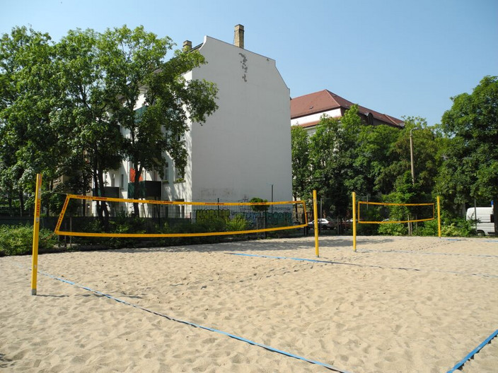 Zwei Beachvolleyballfelder mit Sand und gespannten Volleyballnetzen.