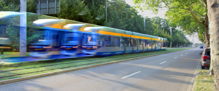 Straßenbahn auf separatem Gleisbett neben einer Straße