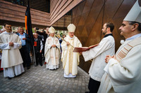 Dr. Heiner Koch, Bischof von Dresden-Meißen, klopft mit seinem Bischofsstab an die Tür der neuen Propsteikirche in Leipzig, um diese für den feierlichen Weiheakt zu öffnen.