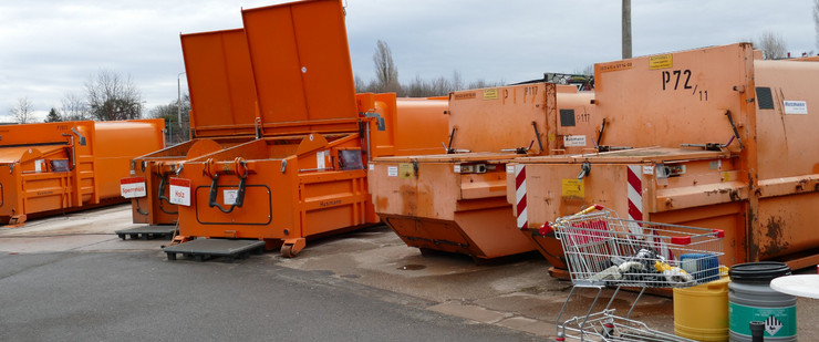 Große, orangefarbene Container stehen auf einem Asphaltplatz