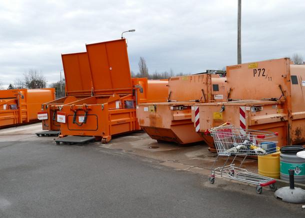 Große, orangefarbene Container stehen auf einem Asphaltplatz