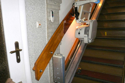 Ein Treppenlift ist an einer Treppe montiert.
