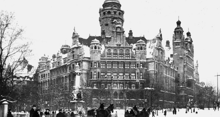 Alte Schwarz-Weiß-Fotografie des Leipziger Neuen Rathauses im Winter 1920. Es liegt Schnee, vor dem Rathaus fahren Pferdekutschen.