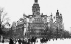 Alte Schwarz-Weiß-Fotografie des Leipziger Neuen Rathauses im Winter 1920. Es liegt Schnee, vor dem Rathaus fahren Pferdekutschen.