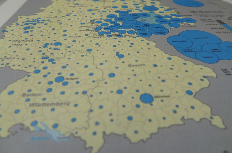 Schräger Blick auf eine Deutschlandkarte mit unterschiedlich großen blauen Kreisen