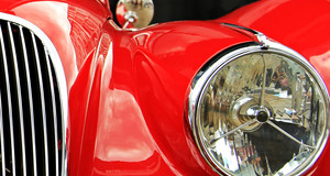 Scheinwerfer und Teil der Motorhaube eines roten Oldtimer-Autos