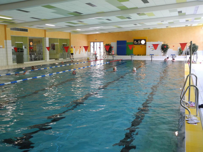 Einzelne Schwimmer schwimmen in der Schwimmbahn der Schwimmhalle Nord.