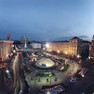 Maydan-Platz mit Glaskuppelhalle und kleinen Bäumen umfasst von Häusern im Stadtzentrum Kyjiws in der Abenddämmerung