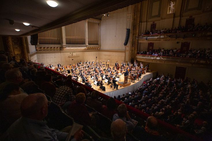 Blick von der Empore auf die Bühne, auf der das Gewandhausorchester spielt. Der Saal ist mit Publikum gefüllt.
