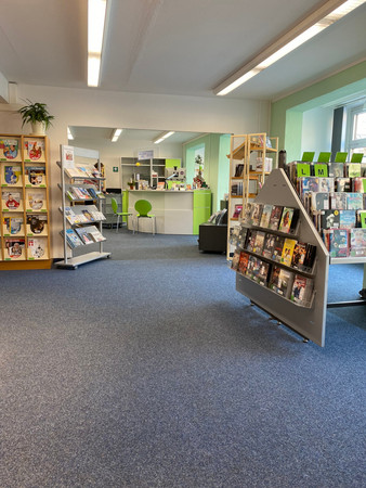 Blick auf die Theke in der Bibliothek Schönefeld im Eingangsbereich aus dem Bereich für AV-Medien.